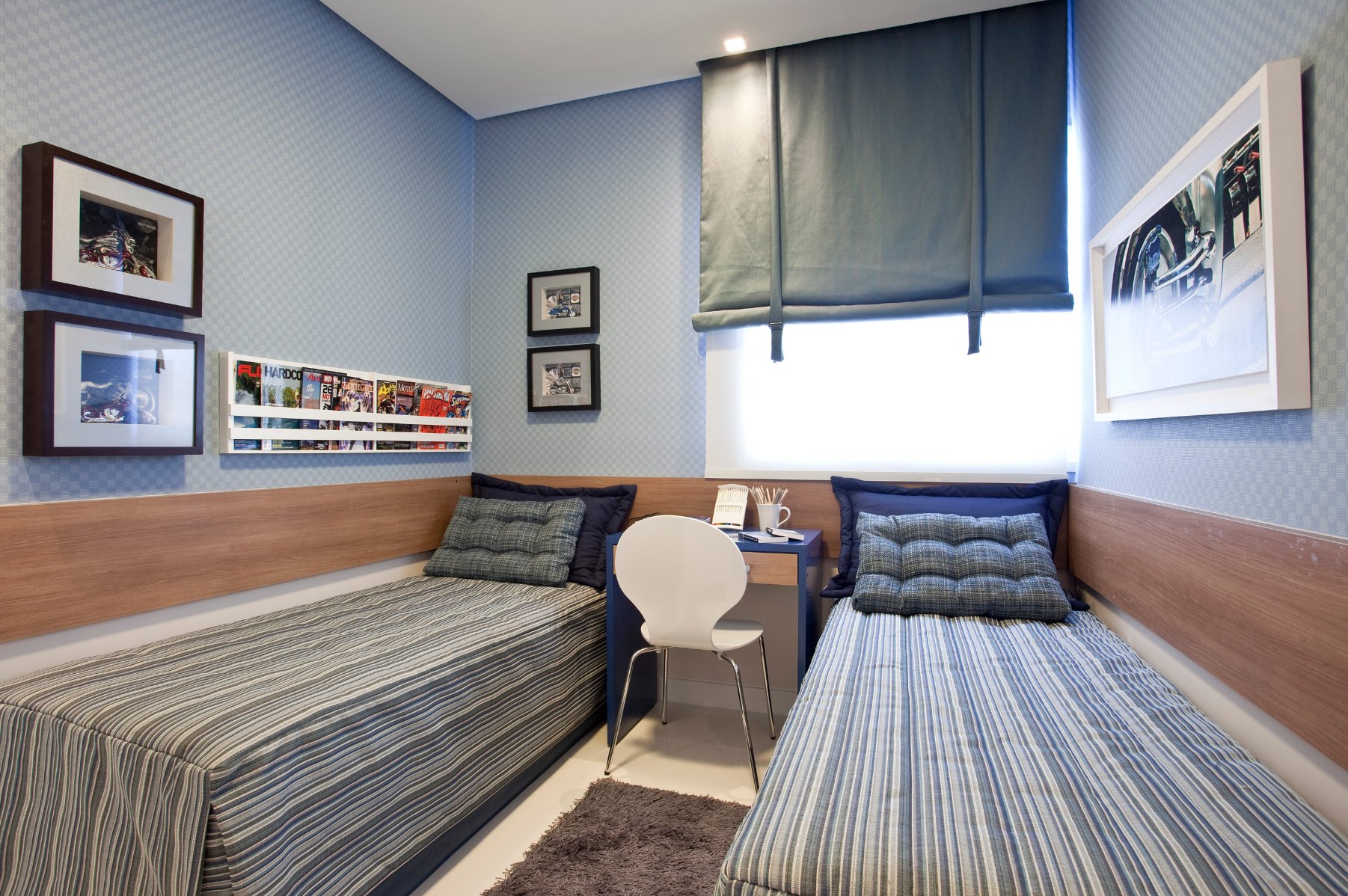 Quarto com duas camas de solteiro, parede azul e escrivaninha