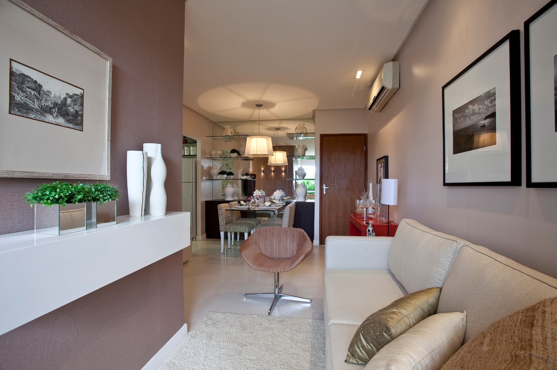 Sala de estar integrada à sala de jantar, com parede em tom lilás e sofá claro